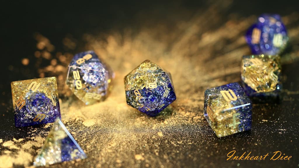 A set of shimmering blue and gold polyhedral dice dazzles on a dark surface, scattered with gold glitter like stardust. Perfect for Friday night adventures, this set includes an array of dice shapes commonly used in tabletop games.